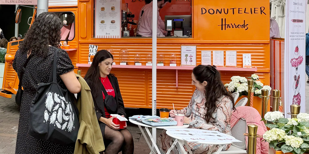 Charlotte Posner painting Pop Doll illustrations at the Donutelier pop-up outside Harrods, London.